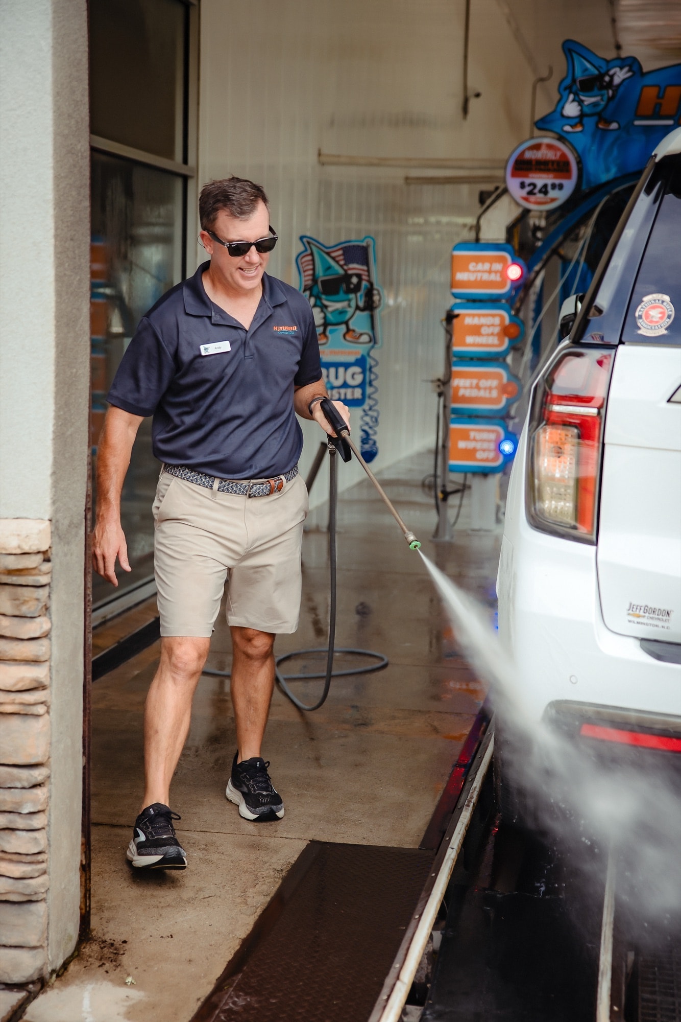 Andy pressure-washing a car before it enters the tunnel
