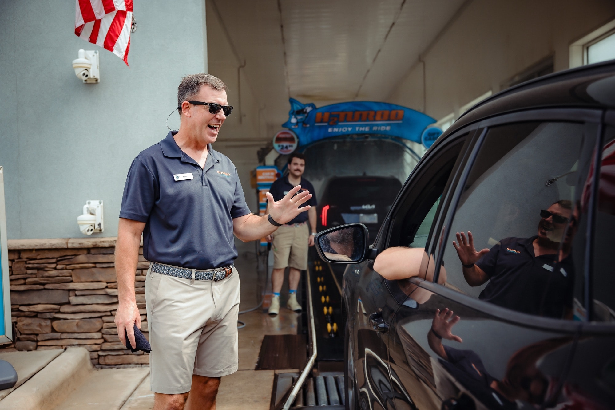 Andy greeting a driver at their window before the wash